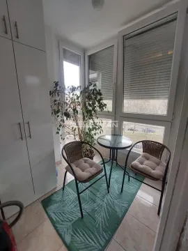 Zastakljeni balkon sa malim stolom, dve stolice i ugrađenim ormarom. - image 14