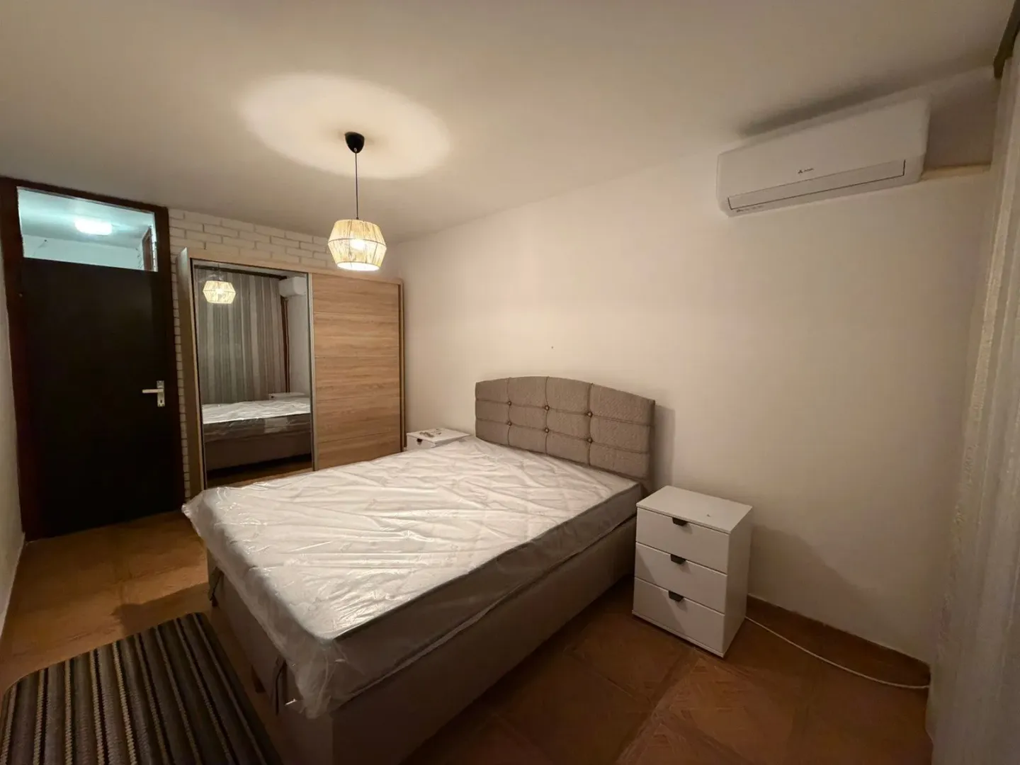 Furnished bedroom with a double bed, wardrobe, and air conditioning.