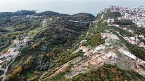 Pogled iz vazduha na brdoviti predio sa prizemnim kućama i zelenilom. - image 6