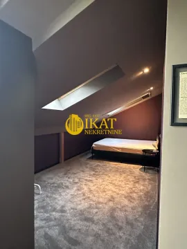 Attic bedroom with a bed and skylights. - image 12