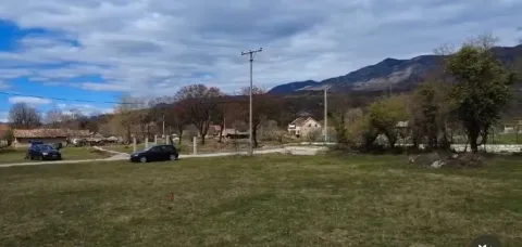 Pogled na plac sa travnatom površinom i okolnim pejzažem. - image 2