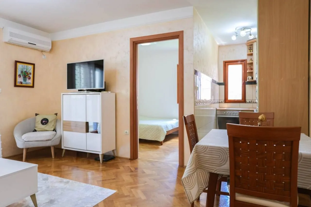 Living room with dining area and a view of the hallway and kitchen.