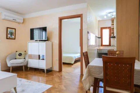 Living room with dining area and a view of the hallway and kitchen. - image 2