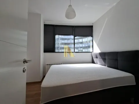 Bedroom with a double bed and a window with blinds. - image 10