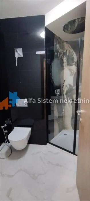 Moderno kupatilo sa tuš kabinom i wc šoljom.