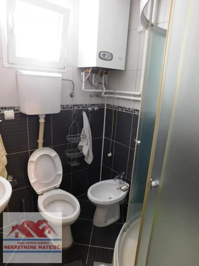 Manje kupatilo sa tuš kabinom, wc šoljom, bideom i bojlerom.