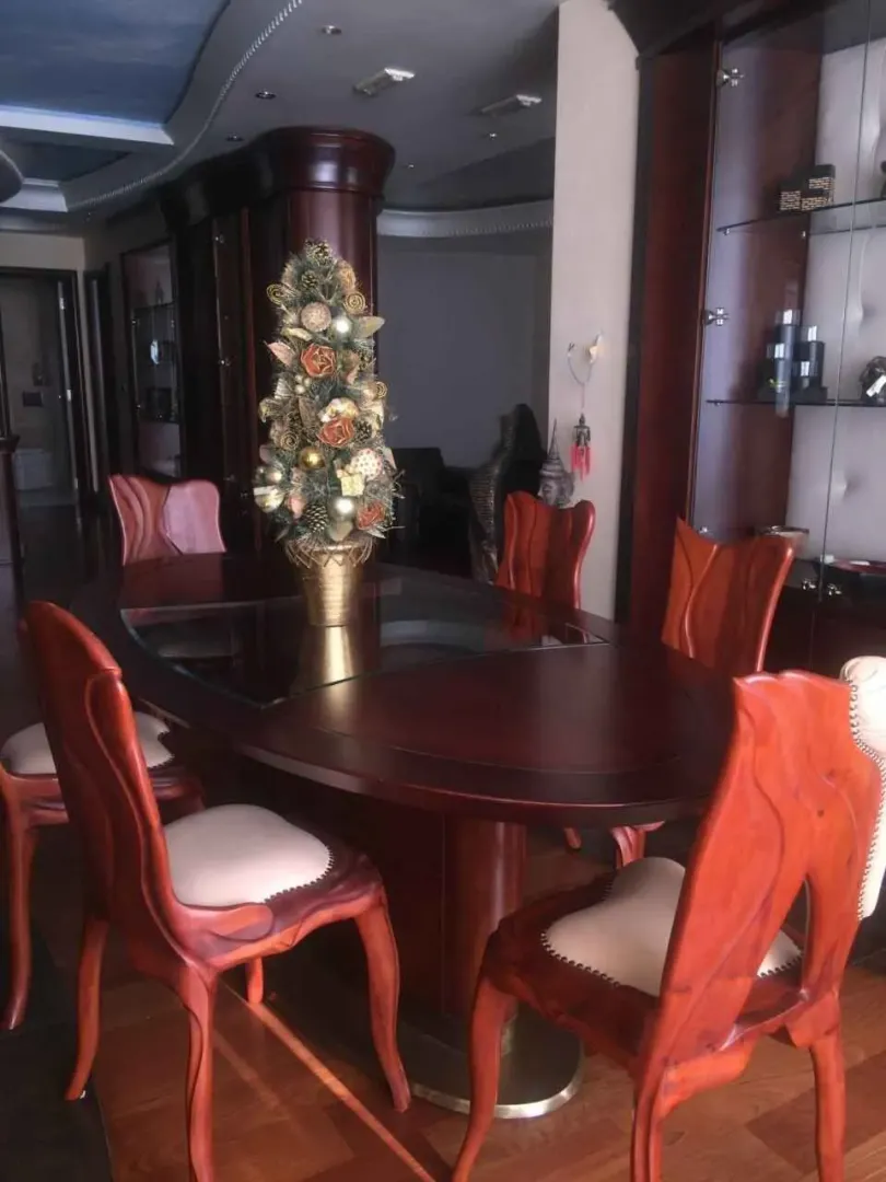 Trpezarija sa velikim drvenim stolom i stolicama.