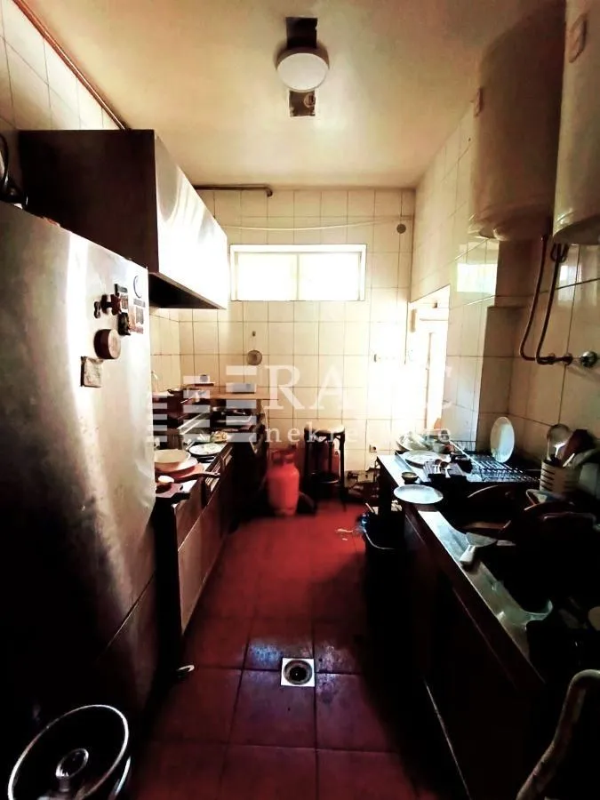 Older and untidy kitchen with dishes and work elements.