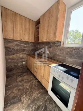 Kuhinja sa drvenim elementima i ugradnim šporetom. - image 4