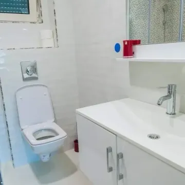 Modernly equipped bathroom with white sanitary ware and a sink. - image 6
