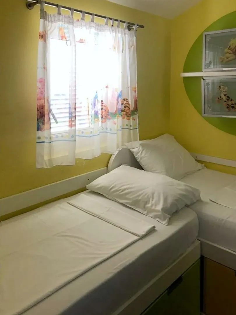 Children's bedroom with two single beds and a window.
