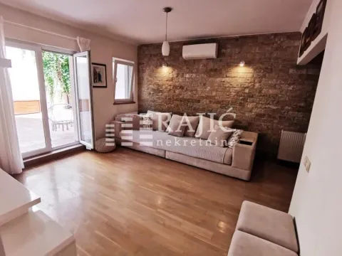 Dnevna soba sa garniturom i zidom obloženim ukrasnim kamenom. - image 11