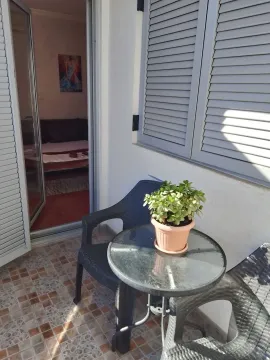 Manji namješteni balkon sa stolom, stolicama i saksijom cvijeća. - image 5