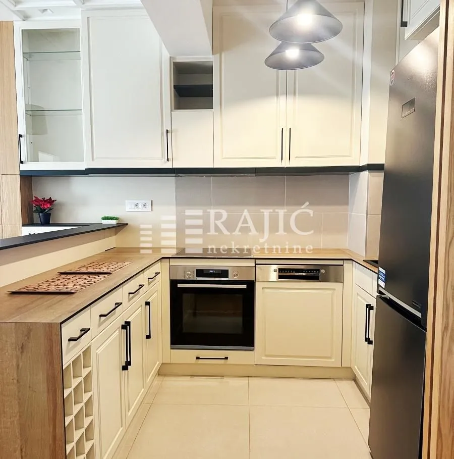 Modern kitchen with light cabinetry and built-in appliances.
