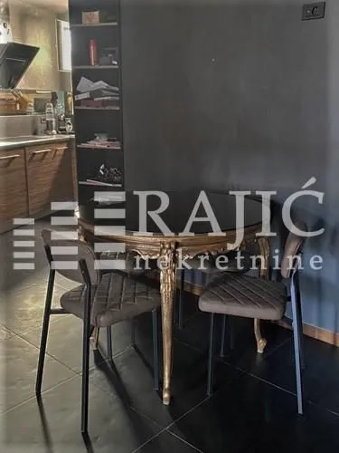 Dining area with a table and chairs next to a dark wall.