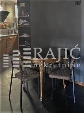 Dining area with a table and chairs next to a dark wall. - image 4