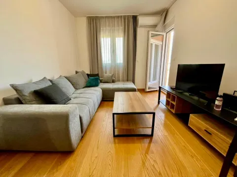 Living room with a large gray sectional sofa, wooden coffee table, and television. - image 2