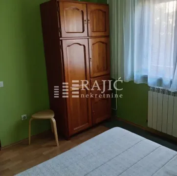 Furnished bedroom with a wooden wardrobe and a bed. - image 7