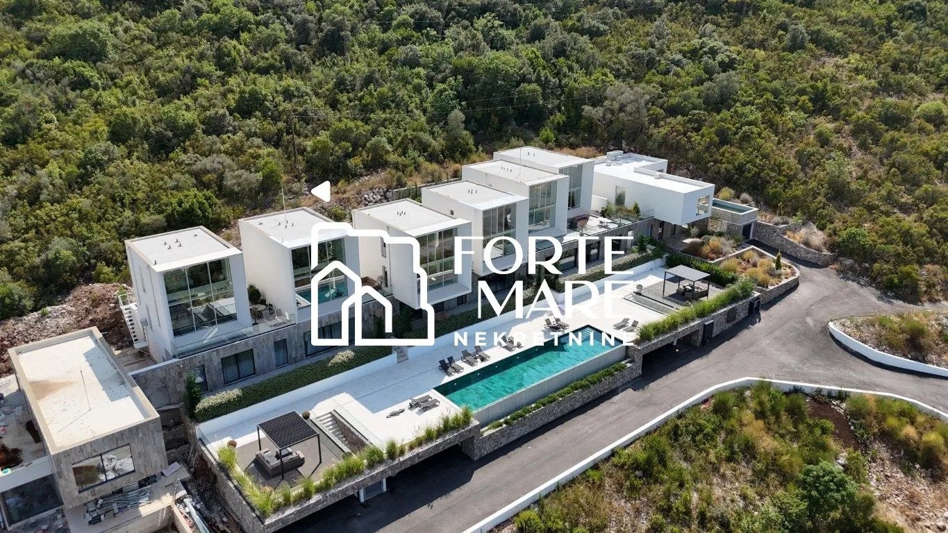 Pogled iz vazduha na kompleks modernih vila sa bazenom u zelenilu.