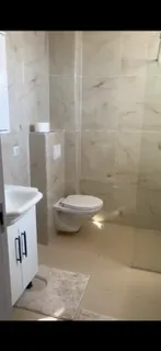 Moderne opremljeno kupatilo sa svijetlim pločicama.