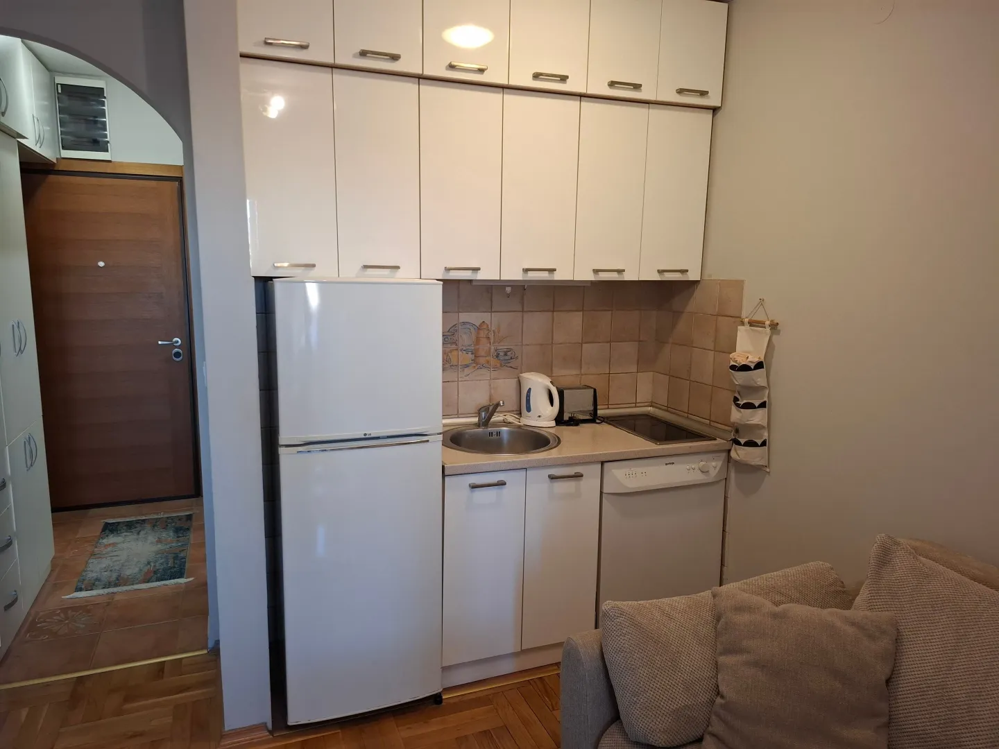 Small kitchen with white cabinets and a refrigerator.