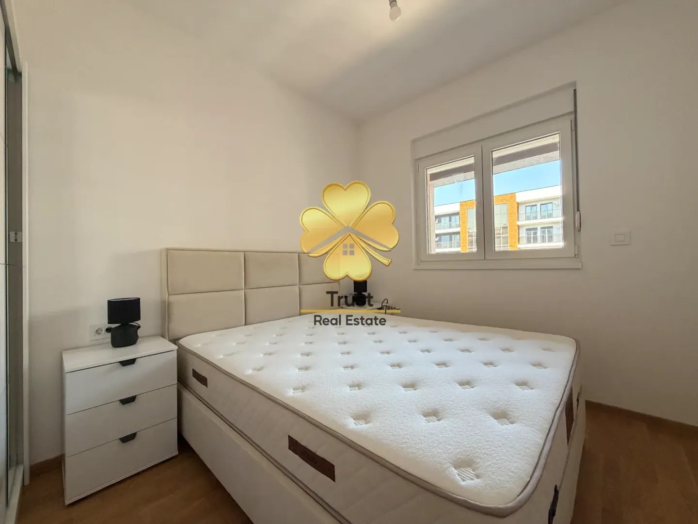 Bright bedroom with a double bed and a nightstand.