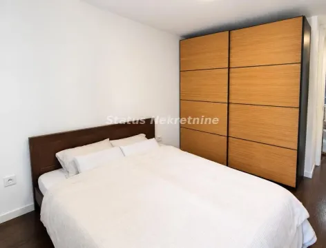 Spavaća soba sa bračnim krevetom i velikim drvenim ormarom. - image 8