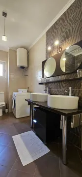 Bathroom with double sinks, shower and washing machine. - image 3