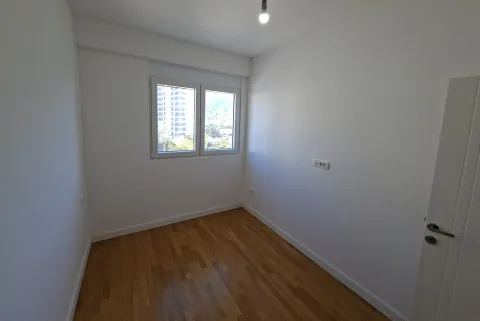 Empty room with white walls, parquet flooring, and a window. - image 4