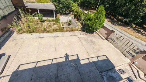 View from the terrace of the paved yard and surrounding greenery. - image 12