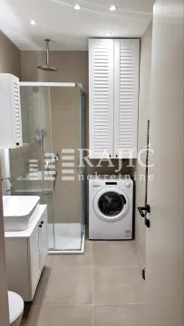 Modernly equipped bathroom with a shower cabin and washing machine. - image 9