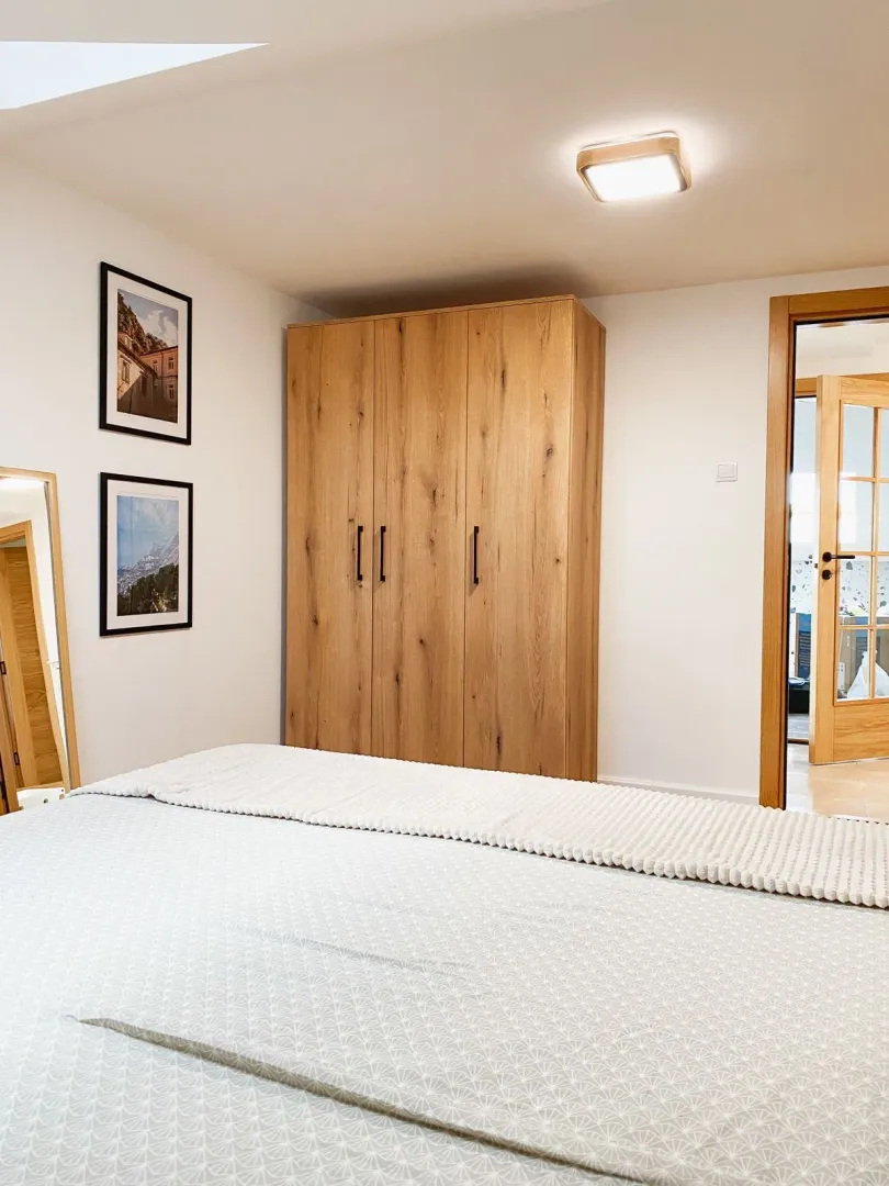 Bedroom with a double bed, wooden wardrobe and wall art.