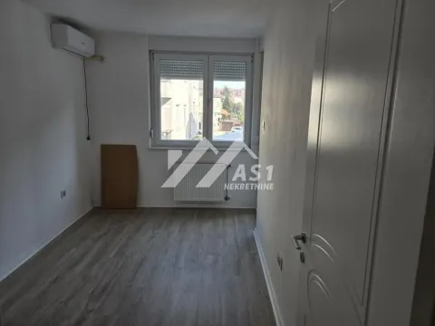 Empty room with a window, air conditioning unit, and laminate flooring. - image 4