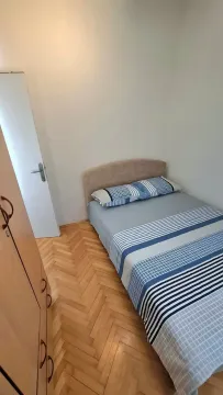 Small bedroom with a bed, wardrobe, and parquet flooring. - image 9