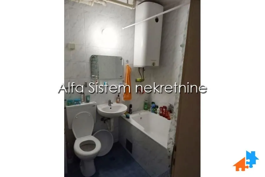 Manje kupatilo sa kadom, umivaonikom, WC šoljom i bojlerom.