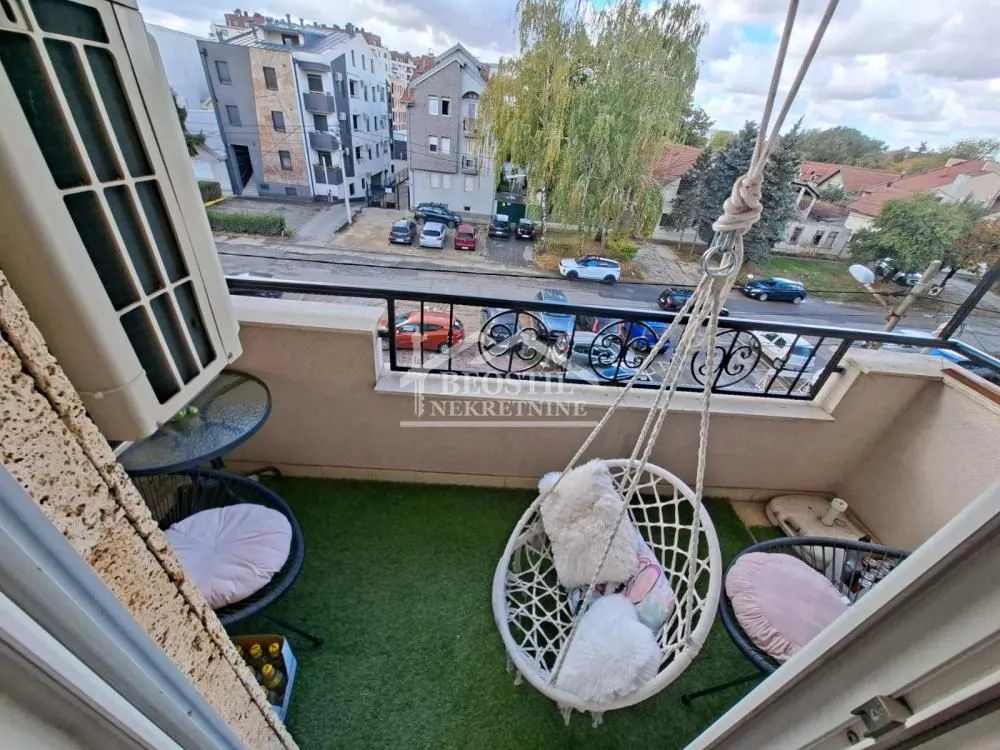 Namješten balkon sa garniturom za sjedenje i pogledom na ulicu.