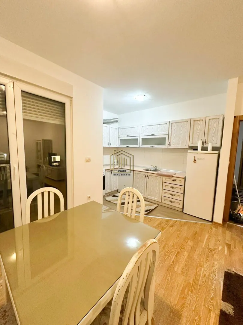 Kitchen with a dining area and light wooden cabinetry.