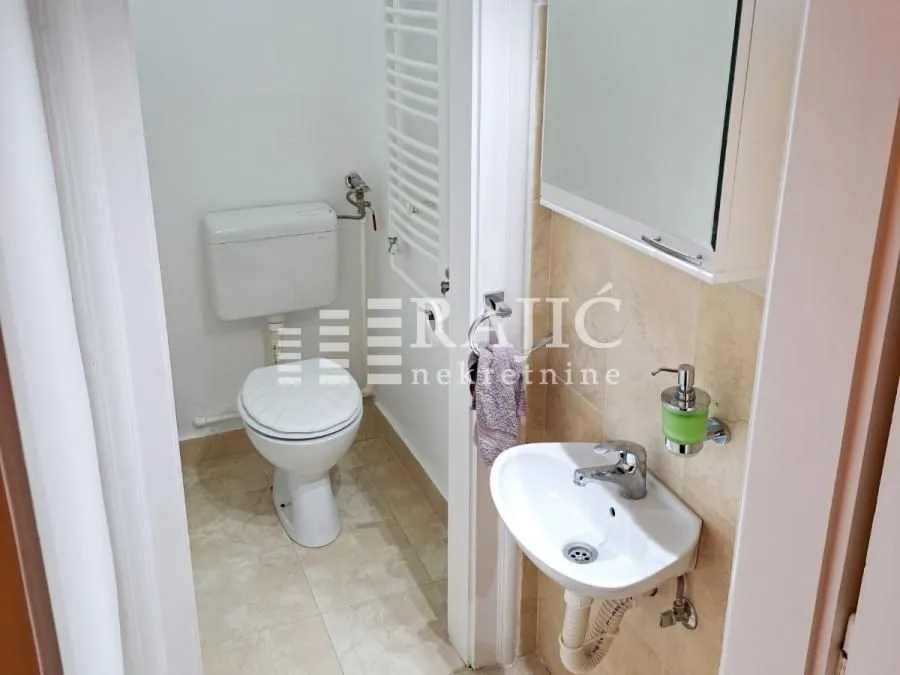Smaller bathroom with a toilet and a sink.