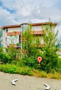 View of a multi-family residential building surrounded by greenery. - image 16