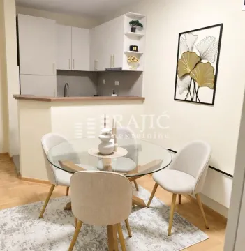 Dining area with a table and chairs overlooking the kitchen. - image 3