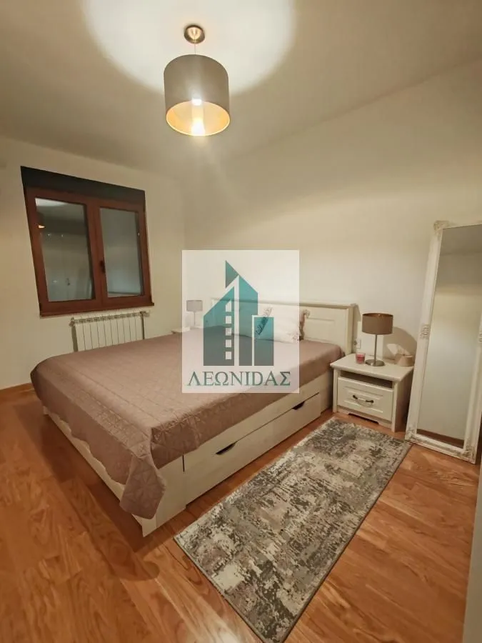 Bedroom with a double bed, nightstand, and mirror.