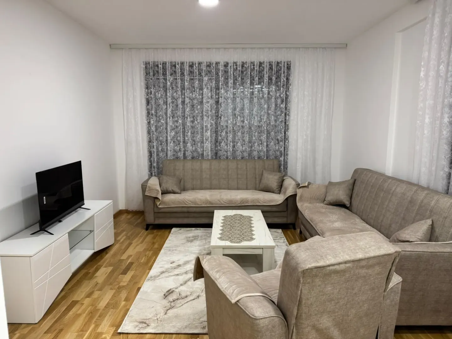 Furnished living room with a sofa set, coffee table, and TV.