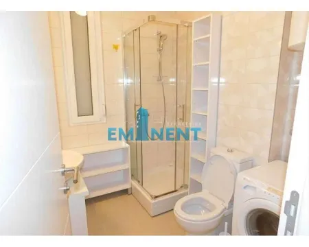 Bathroom with a shower cabin, toilet, washbasin, and washing machine. - image 2