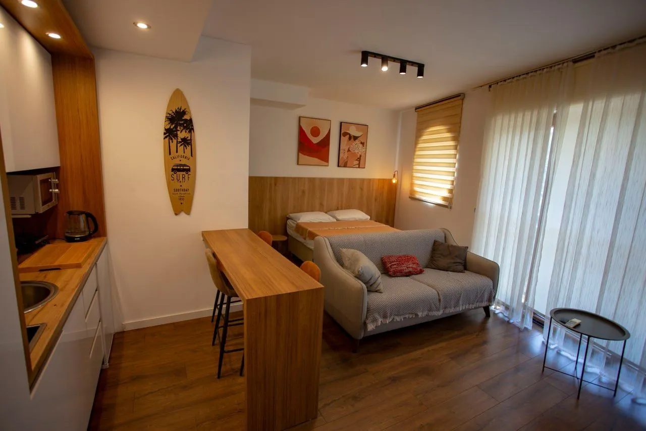 Modern and bright studio apartment with a seating area and bed.