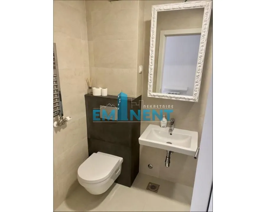 Modern bathroom with a toilet, washbasin, and mirror.