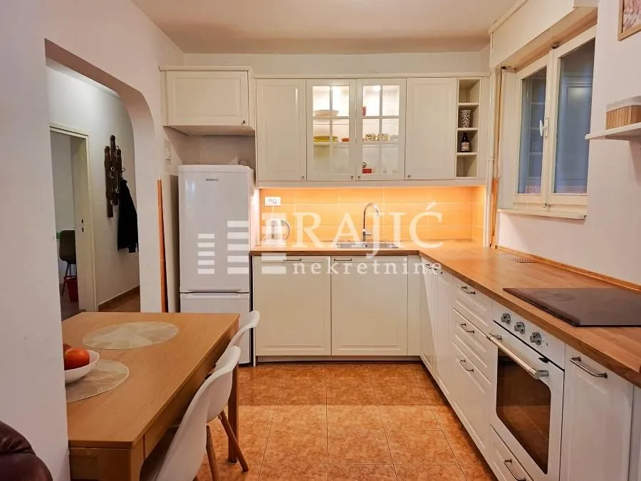 Bright kitchen with white cabinetry and a dining table.