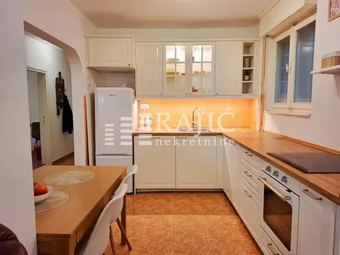 Bright kitchen with white cabinetry and a dining table. - image 9