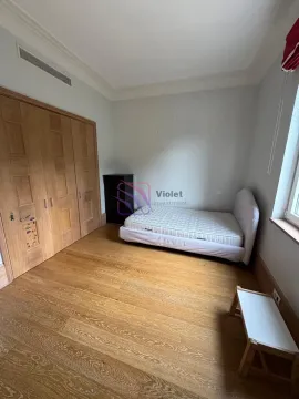 Bedroom with a bed, wooden wardrobe, and wooden flooring. - image 13