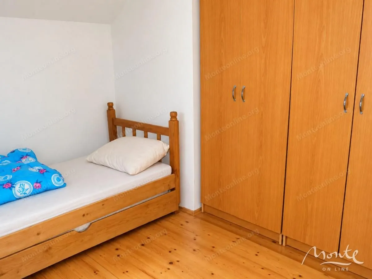 Small bedroom with a wooden bed and a wardrobe.