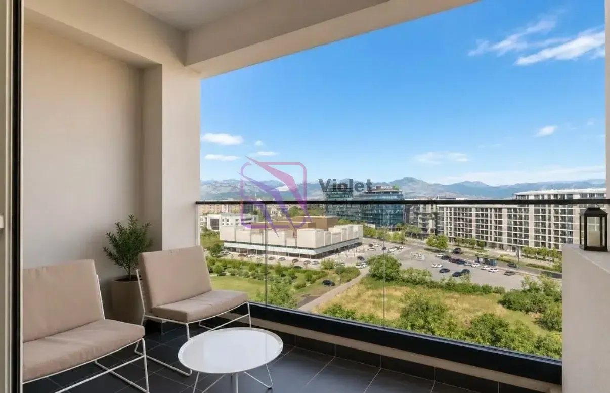 Covered balcony with seating furniture and city view.